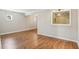 An empty living room featuring hardwood floors, light gray paint, and a small passthrough window at 3091 Colonial Way # F2, Atlanta, GA 30341