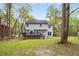 Two-story home featuring a backyard with a large deck and lush green lawn at 7275 Oswego Trl, Riverdale, GA 30296