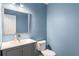 Powder room featuring blue walls, modern vanity with chrome faucet, and a white framed mirror at 7275 Oswego Trl, Riverdale, GA 30296
