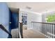 Upstairs hallway with staircase, modern railing, and view into room at 225 Mary Jane Ln, Covington, GA 30016