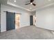Bright bedroom features a ceiling fan, gray carpet and a sliding barn door at 2286 Carver Nw Dr, Atlanta, GA 30314