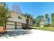 View of the home exterior, including a two-car garage and a basketball court at 313 Fayette Villa Ct, Fayetteville, GA 30214