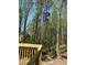 Wooded backyard viewed from the home's wood deck with railing and trees in the background at 5851 Swan Walk, Sugar Hill, GA 30518