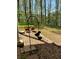 Backyard bird feeder with decorative hanging bird feeder and flower beds with trees in the background at 5851 Swan Walk, Sugar Hill, GA 30518