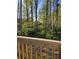 View of the natural wooded environment as seen from a deck with wooden railings at 5851 Swan Walk, Sugar Hill, GA 30518