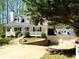 Charming two-story home with a stone retaining wall, long driveway, and a three car garage at 5851 Swan Walk, Sugar Hill, GA 30518