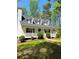 Inviting two-story home featuring a classic white porch, well-manicured lawn, and mature trees at 5851 Swan Walk, Sugar Hill, GA 30518