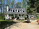 Charming Cape Cod-style home with white siding, dormer windows, and a cozy front porch at 5851 Swan Walk, Sugar Hill, GA 30518