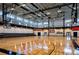 Spacious gymnasium with hardwood floors, high ceilings, basketball hoops, and ample natural light, perfect for recreational activities at 5851 Swan Walk, Sugar Hill, GA 30518