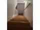 Well-lit wooden stairway featuring white risers, a handrail, and wall sconces at 5851 Swan Walk, Sugar Hill, GA 30518