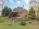 Beautiful backyard with lush landscaping, stone retaining wall, and iron fencing at 7405 Richmond Way, Cumming, GA 30040