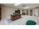 Spacious basement office area with a large desk, tile flooring and recessed lighting at 7405 Richmond Way, Cumming, GA 30040