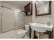 Cozy bathroom features a shower, toilet, sink, and dark wood cabinet for storage at 7405 Richmond Way, Cumming, GA 30040