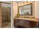 Bathroom with granite counters, wood cabinets, and tiled shower with glass door, and great lighting at 7405 Richmond Way, Cumming, GA 30040