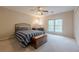Comfortable bedroom featuring a ceiling fan, a desk and a large window with outdoor views at 7405 Richmond Way, Cumming, GA 30040