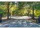 The gated entrance to a residential community, framed by trees and featuring a glimpse of the playground at 7405 Richmond Way, Cumming, GA 30040