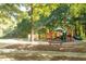 A community playground with slides and climbing structures, shaded by mature trees and lush greenery at 7405 Richmond Way, Cumming, GA 30040