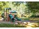 A colorful community playground with slides, climbing structures, and benches, surrounded by mature trees at 7405 Richmond Way, Cumming, GA 30040