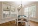Bright dining room with hardwood floors, large windows, modern lighting, and a white dining set at 7405 Richmond Way, Cumming, GA 30040