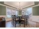 Elegant dining room featuring a modern chandelier, large windows and hardwood floors at 7405 Richmond Way, Cumming, GA 30040