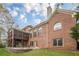 Backyard exterior showcasing a brick home with a screened-in porch and patio at 7405 Richmond Way, Cumming, GA 30040