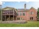 Brick home boasts a backyard with a screened-in porch, patio, and well-manicured lawn at 7405 Richmond Way, Cumming, GA 30040