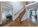Grand foyer with hardwood floors, iron-spindled staircase, and views of the living spaces at 7405 Richmond Way, Cumming, GA 30040