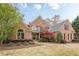 Charming brick home with a lush front yard and mature landscaping at 7405 Richmond Way, Cumming, GA 30040