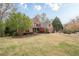 Beautiful two-story brick home with a well-manicured lawn, mature trees, and a paved driveway at 7405 Richmond Way, Cumming, GA 30040