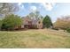 Beautiful brick home with a well-manicured lawn, mature trees, and a long driveway at 7405 Richmond Way, Cumming, GA 30040
