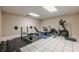 Home gym features weights, workout machines, and a clean, tiled floor at 7405 Richmond Way, Cumming, GA 30040