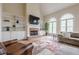 Bright living room with hardwood floors, a brick fireplace, built-in shelving and large windows at 7405 Richmond Way, Cumming, GA 30040