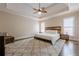 Serene main bedroom with a tray ceiling, ceiling fan, and hardwood floors at 7405 Richmond Way, Cumming, GA 30040