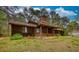 Rustic wood home with a covered porch, stone foundation, and mature trees surrounding the property at 2140 Teri Ln, Conyers, GA 30013