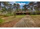 Single-story home with a long driveway surrounded by mature trees at 2140 Teri Ln, Conyers, GA 30013