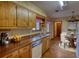 Traditional kitchen with wood cabinets, a stainless steel sink, and an adjacent dining area at 2140 Teri Ln, Conyers, GA 30013