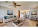 Bright living room featuring neutral walls, a ceiling fan, and an open dining area perfect for entertaining at 2140 Teri Ln, Conyers, GA 30013