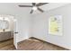 Bright bedroom with wood floors, ceiling fan, and adjacent bathroom; natural light from the window at 437 Collier Ridge Nw Dr, Atlanta, GA 30318