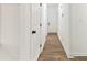 Well-lit hallway featuring wood-look flooring and white doors with black hardware at 437 Collier Ridge Nw Dr, Atlanta, GA 30318