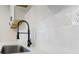 A close-up on the kitchen's modern faucet, quartz countertop, and textured backsplash at 437 Collier Ridge Nw Dr, Atlanta, GA 30318