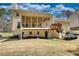 Back of the house, revealing a sunroom, access to the basement, and beautiful lawn at 4814 Riveredge Cv, Snellville, GA 30039