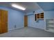 Clean basement with painted blue walls and floor, featuring storage shelves and two doors at 4814 Riveredge Cv, Snellville, GA 30039