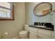 Bathroom features a marble vanity top, white cabinetry, and a framed mirror at 4814 Riveredge Cv, Snellville, GA 30039