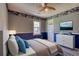 Cozy bedroom with blue accents, featuring a ceiling fan and a scenic mountain view art piece at 4814 Riveredge Cv, Snellville, GA 30039