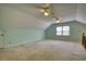 Bright bonus room featuring a vaulted ceiling, dual fans, and natural light from the window at 4814 Riveredge Cv, Snellville, GA 30039