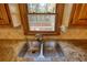 Stainless steel kitchen sink with a window view of the backyard deck and landscaping at 4814 Riveredge Cv, Snellville, GA 30039