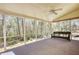 Enclosed sunroom with large windows and ceiling fan, offering views of the surrounding woods at 4814 Riveredge Cv, Snellville, GA 30039