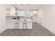 Modern kitchen with white cabinets, gray backsplash, stainless steel appliances, and gray laminate flooring at 5469 Helen Pl Sw, Mableton, GA 30126