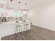 Modern kitchen with white cabinets, gray backsplash, stainless steel appliances, and gray laminate flooring at 5469 Helen Pl Sw, Mableton, GA 30126