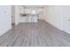 Open concept living space with gray laminate flooring, white walls, and a modern kitchen at 5469 Helen Pl Sw, Mableton, GA 30126